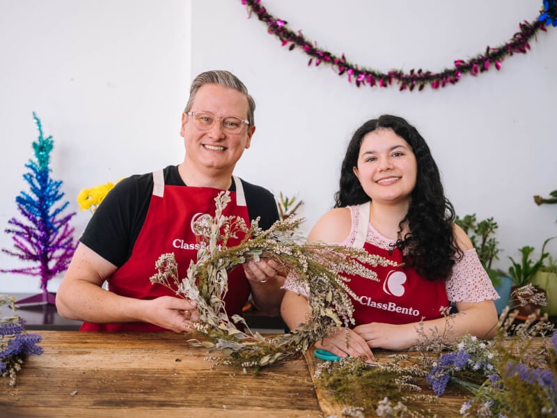 Man and woman holding DIY Christmas wreath